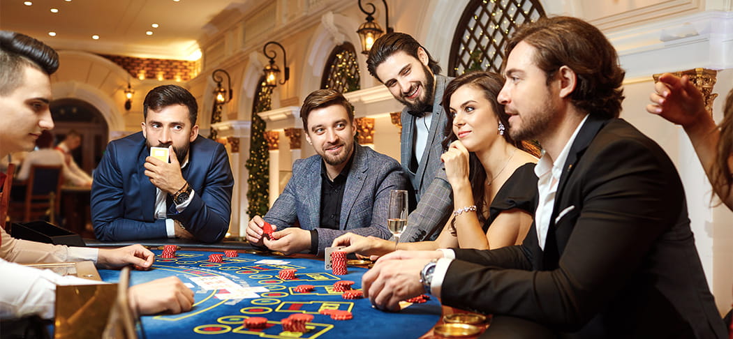 Players sit around a blackjack table.