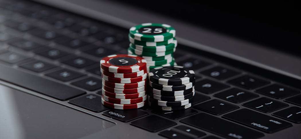 Poker chips sit atop a laptop.