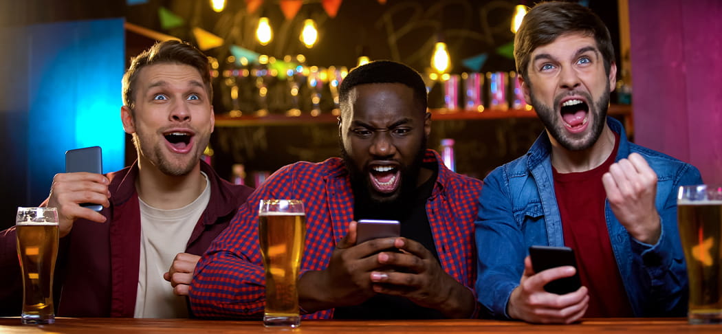 Three buddies watching sports at a bar.