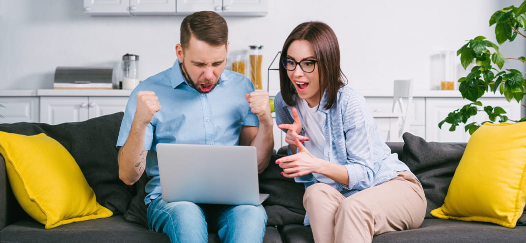 Two people watch sports on their computer.