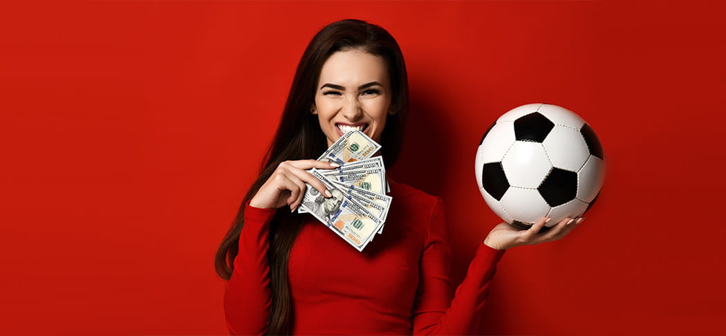 A woman holds cash and a soccer ball.